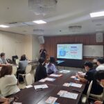 講師が認知症ケアプログラムの考え方をスライドで説明している様子