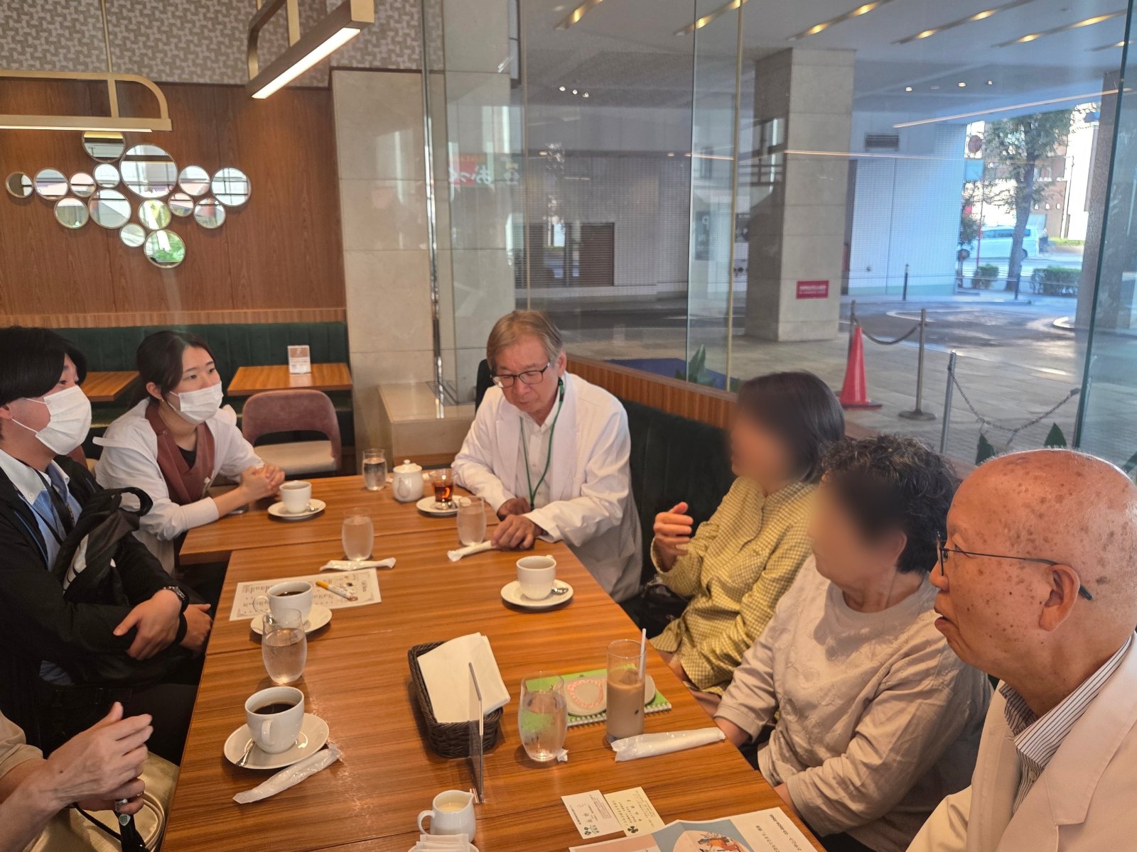 ホテルのカフェで医師・看護師と参加者がテーブルを囲んで話している様子